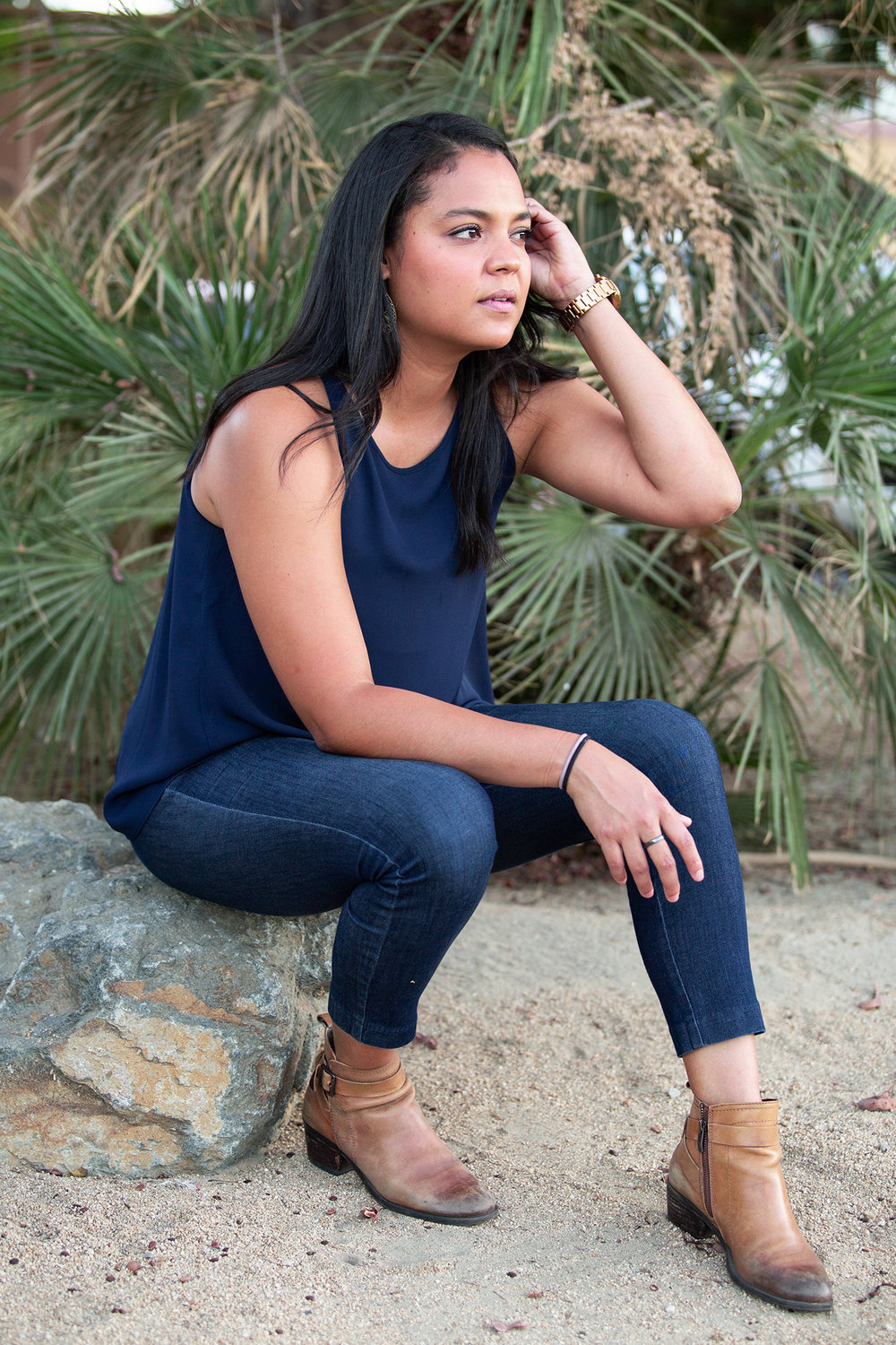 Edith Carolina Rojas sitting on a rock in a contemplative state.